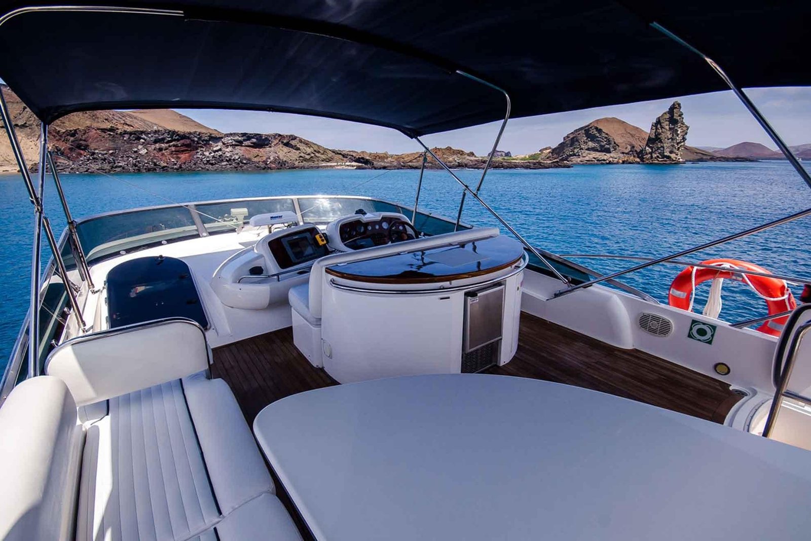 Comfortable yacht deck overlooking the sea and volcanic scenery in the Galapagos Islands.